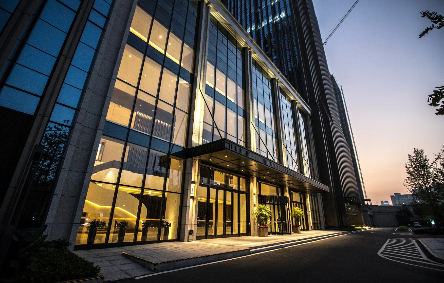 Modern commercial building exterior illuminated at dusk showcasing professional property management and upscale real estate.